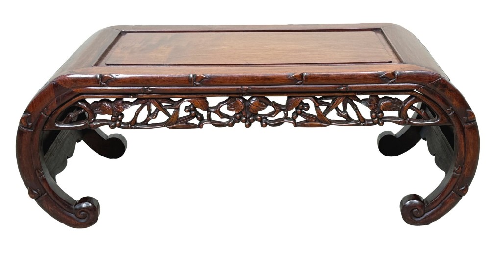 A 19th-century dark hardwood Chinese export opium coffee table featuring scrolled legs and intricately carved pierced floral aprons. View X