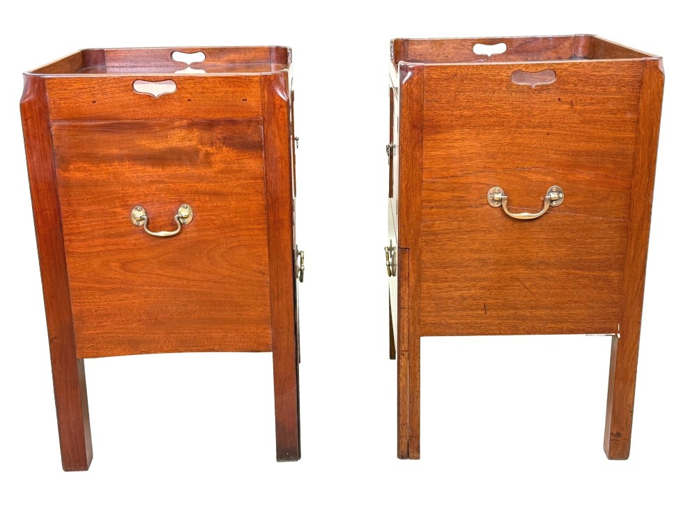 A matched pair of Georgian mahogany bedside tables featuring top tray galleries with cutout handles, double cupboard doors, lower drawers, and brass hardware. View IV
