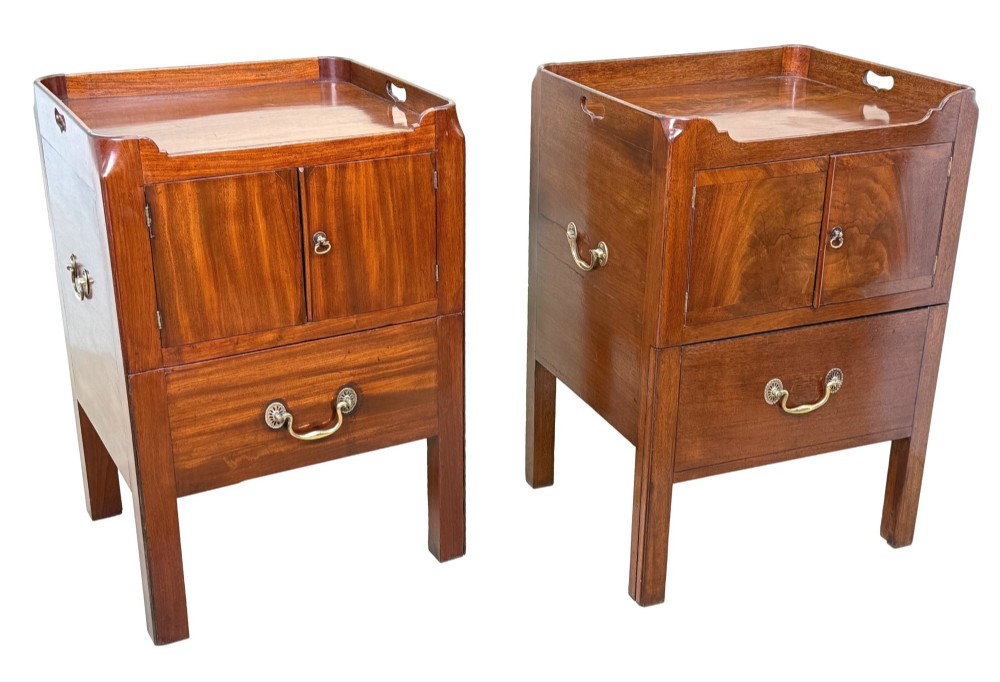 A matched pair of Georgian mahogany bedside tables featuring top tray galleries with cutout handles, double cupboard doors, lower drawers, and brass hardware. View VII