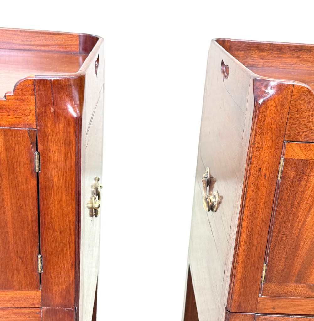 A matched pair of Georgian mahogany bedside tables featuring top tray galleries with cutout handles, double cupboard doors, lower drawers, and brass hardware. View VIII