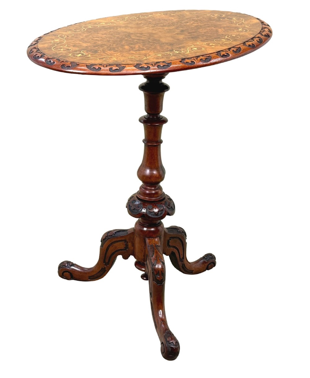 A Victorian burr walnut oval occasional table with marquetry inlay top, a turned central pedestal, and carved tripod cabriole feet. View VII