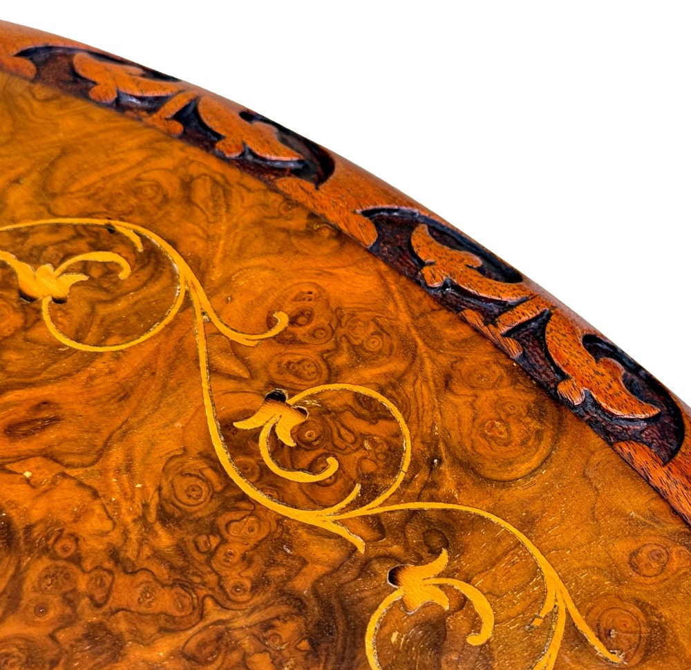 A Victorian burr walnut oval occasional table with marquetry inlay top, a turned central pedestal, and carved tripod cabriole feet. View VIII