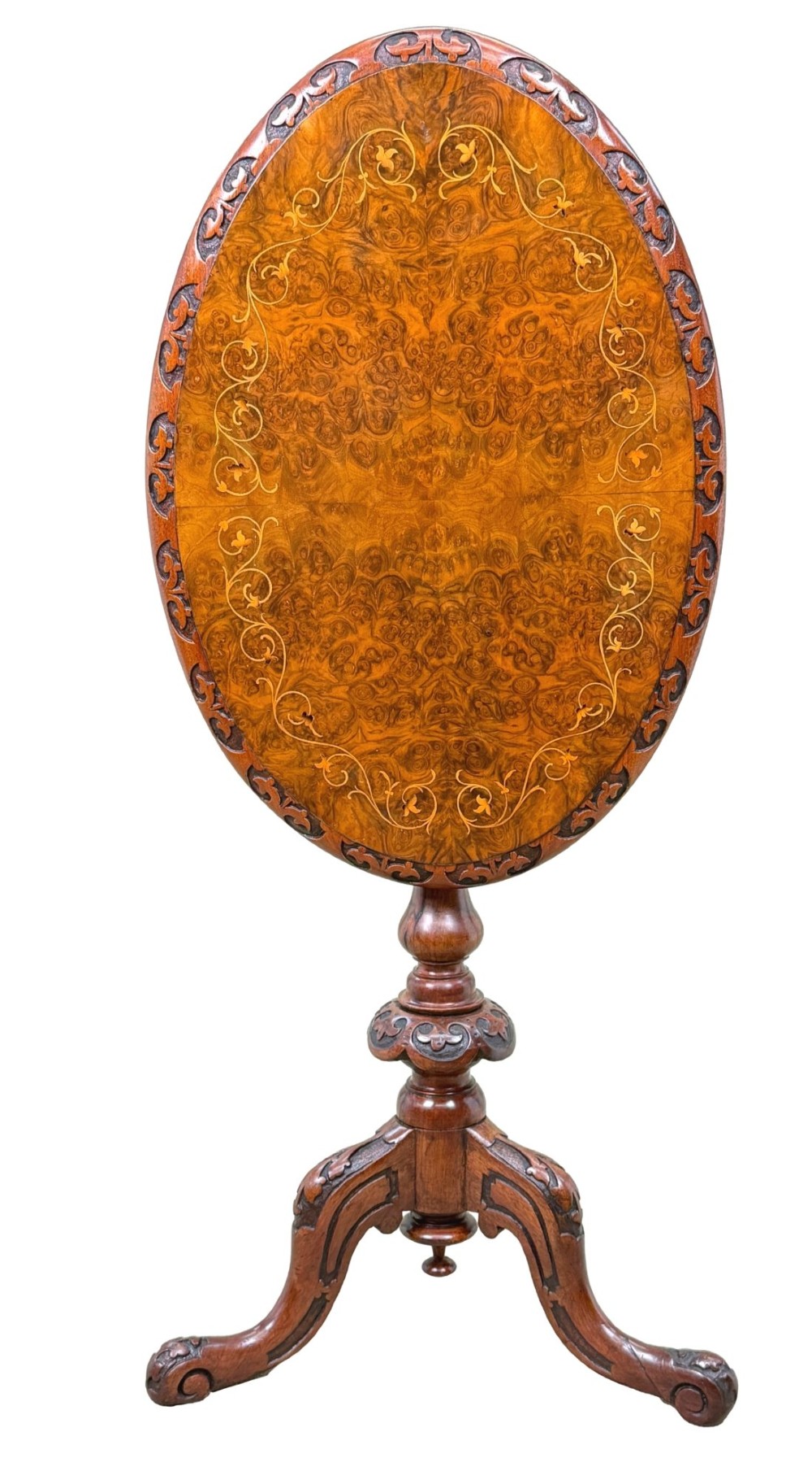 A Victorian burr walnut oval occasional table with marquetry inlay top, a turned central pedestal, and carved tripod cabriole feet. View X