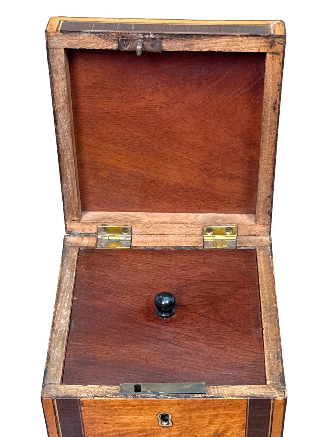 A square Georgian satinwood tea caddy featuring dark wood crossbanded borders, a central brass keyhole escutcheon, and four brass ball feet. View IV