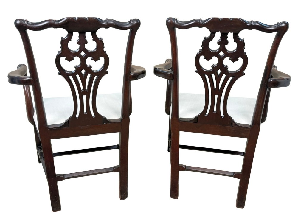 A pair of 18th-century Chippendale mahogany carver armchairs featuring intricately carved pierced back splats, curved arms, and neutral upholstered drop-in seats. View X