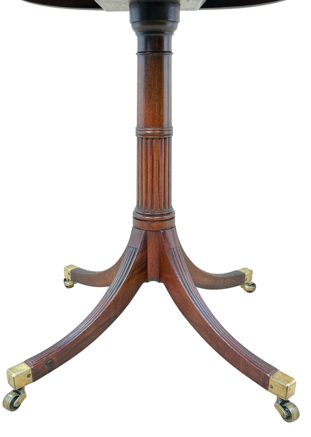 Late eighteenth-century George III mahogany circular lamp table featuring a fluted stem and four reeded legs with brass castors. View III