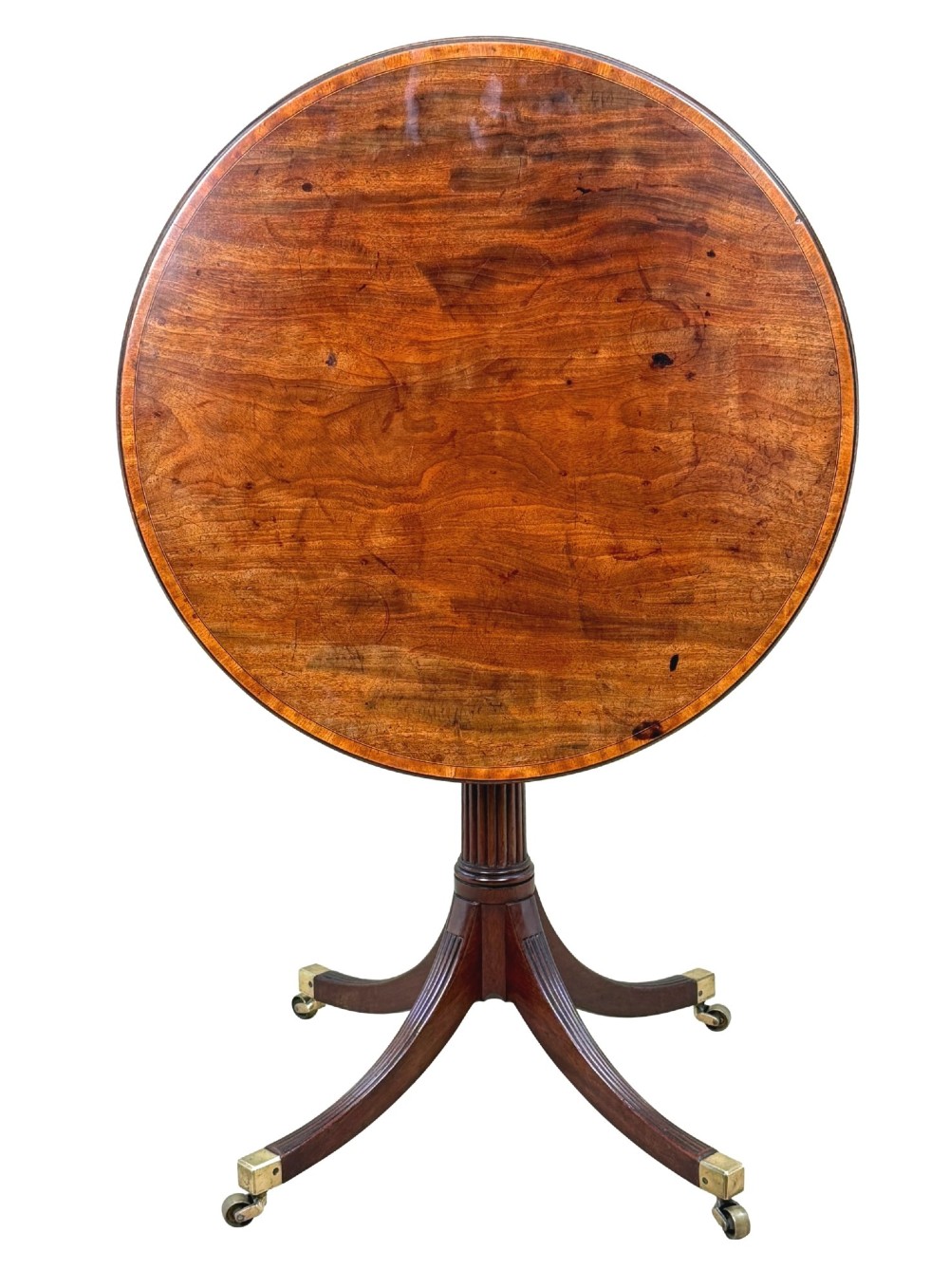 Late eighteenth-century George III mahogany circular lamp table featuring a fluted stem and four reeded legs with brass castors. View VII
