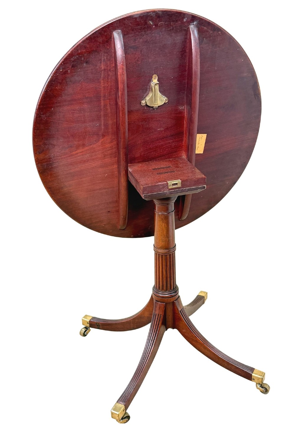 Late eighteenth-century George III mahogany circular lamp table featuring a fluted stem and four reeded legs with brass castors. View X
