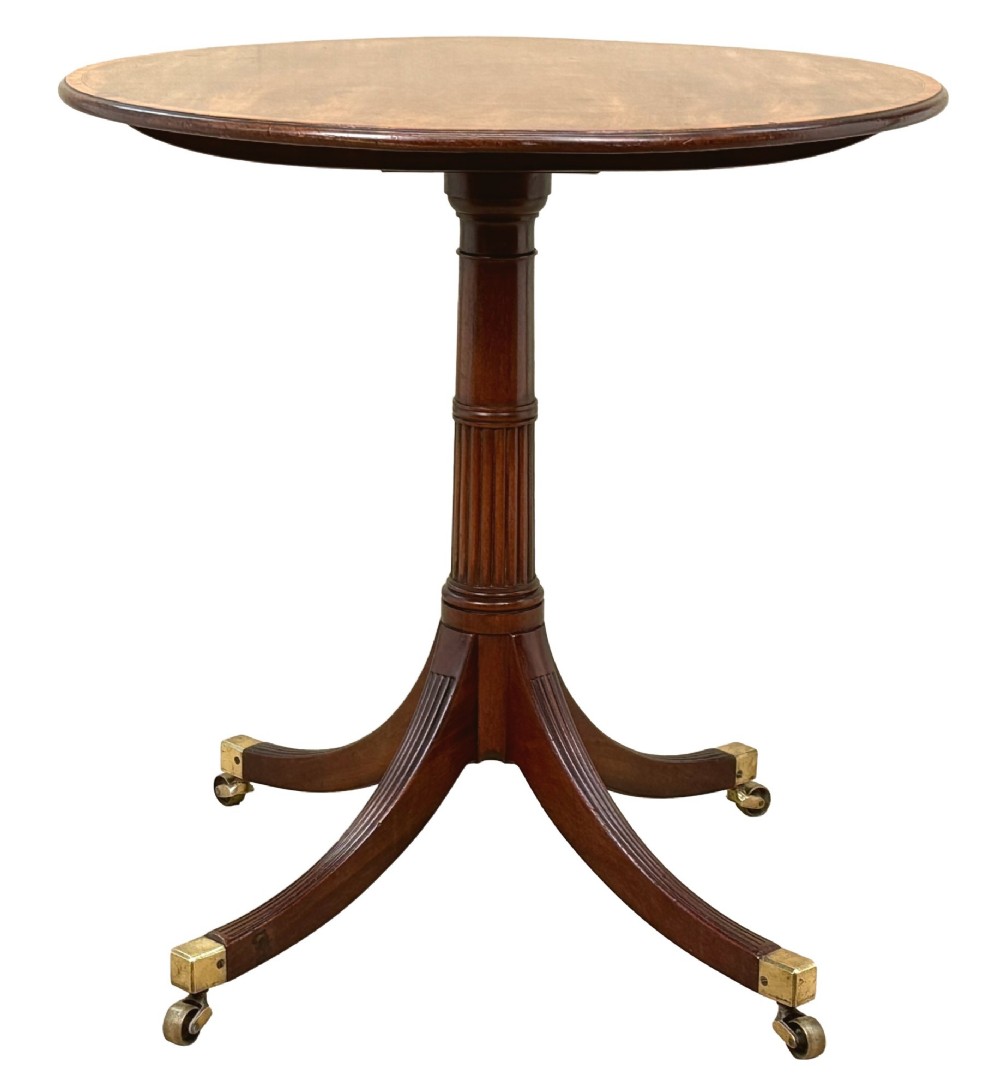 Late eighteenth-century George III mahogany circular lamp table featuring a fluted stem and four reeded legs with brass castors. View XI