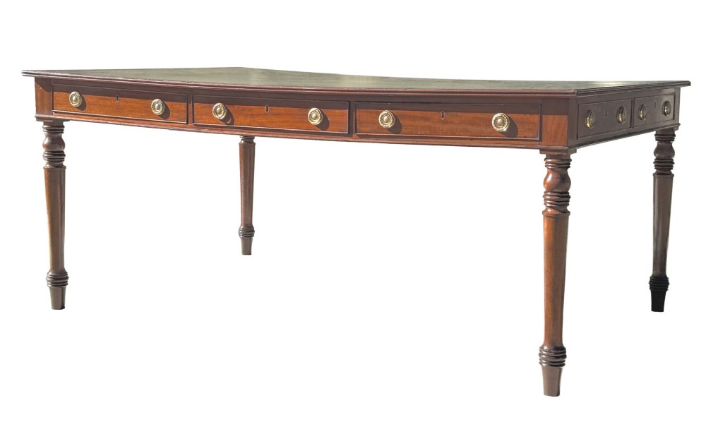 A large 19th-century Georgian mahogany partners writing table with frieze drawers, brass handles, turned legs, and a dark leather writing surface.
