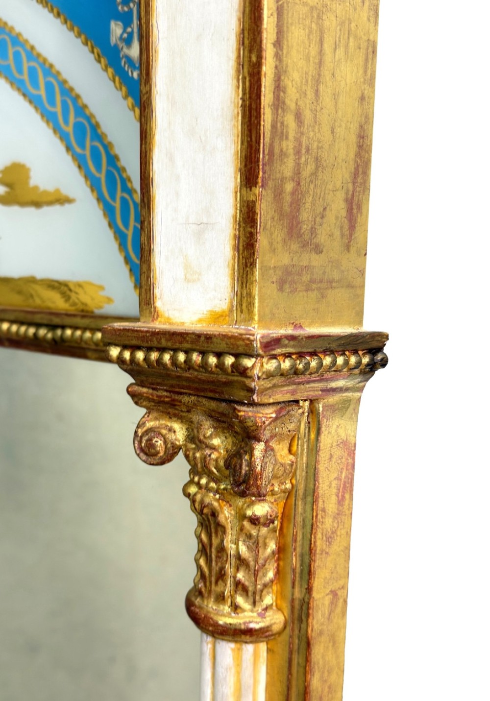 A pair of tall early 19th-century Regency pier mirrors featuring gilded pilasters, breakfront cornices, and upper painted panels depicting maritime sailing vessels. View III