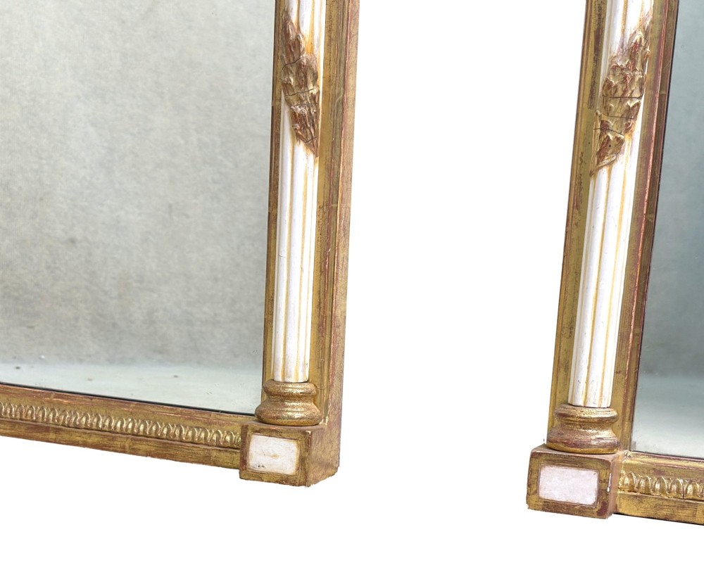 A pair of tall early 19th-century Regency pier mirrors featuring gilded pilasters, breakfront cornices, and upper painted panels depicting maritime sailing vessels. View VI