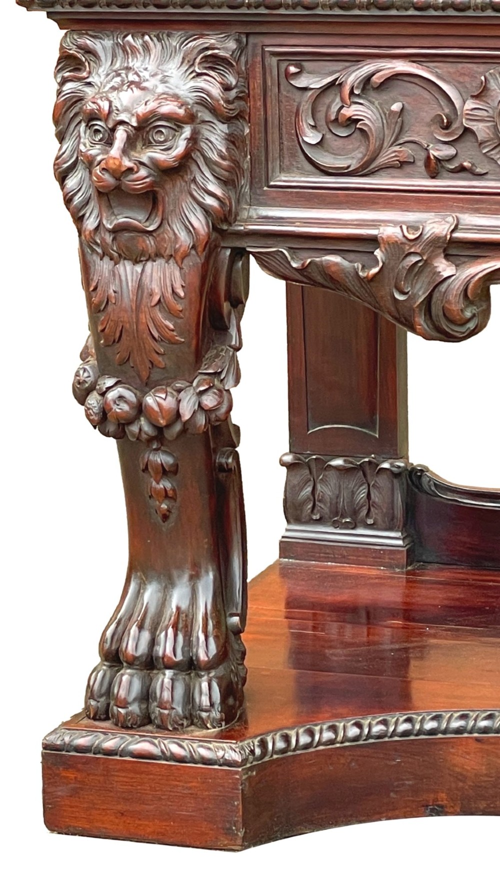 A 19th-century dark mahogany display cabinet featuring a carved crest, glazed doors, and lower support with carved lion mask legs. View II