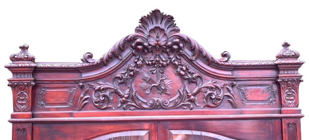 A 19th-century dark mahogany display cabinet featuring a carved crest, glazed doors, and lower support with carved lion mask legs. View III