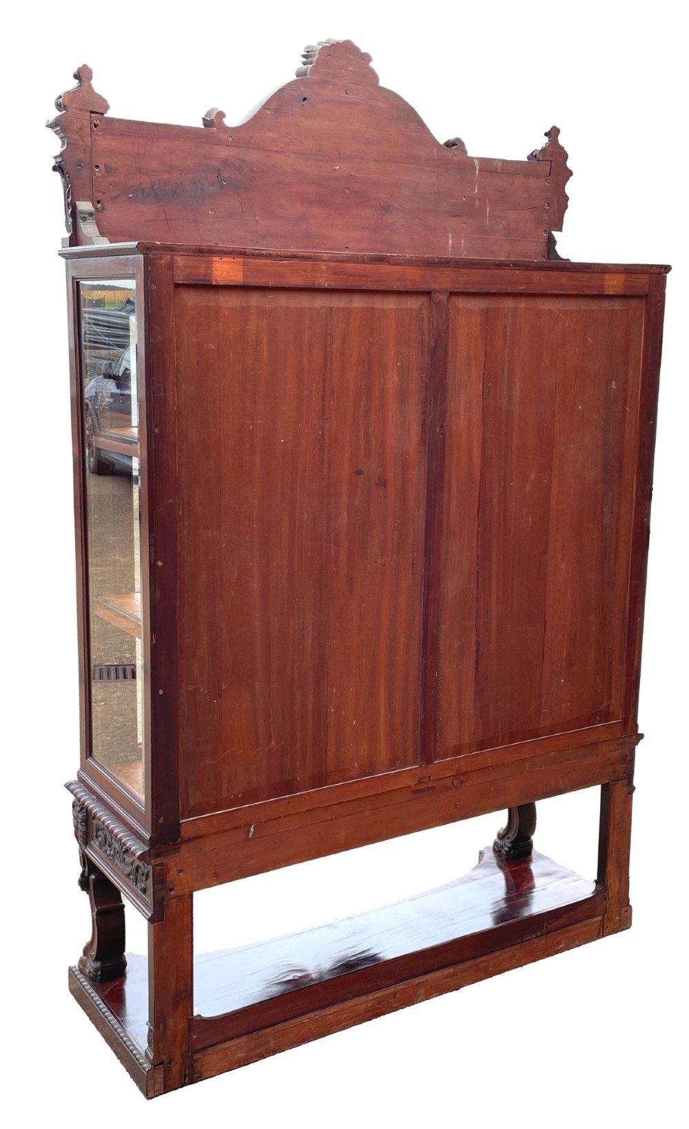 A 19th-century dark mahogany display cabinet featuring a carved crest, glazed doors, and lower support with carved lion mask legs. View XI