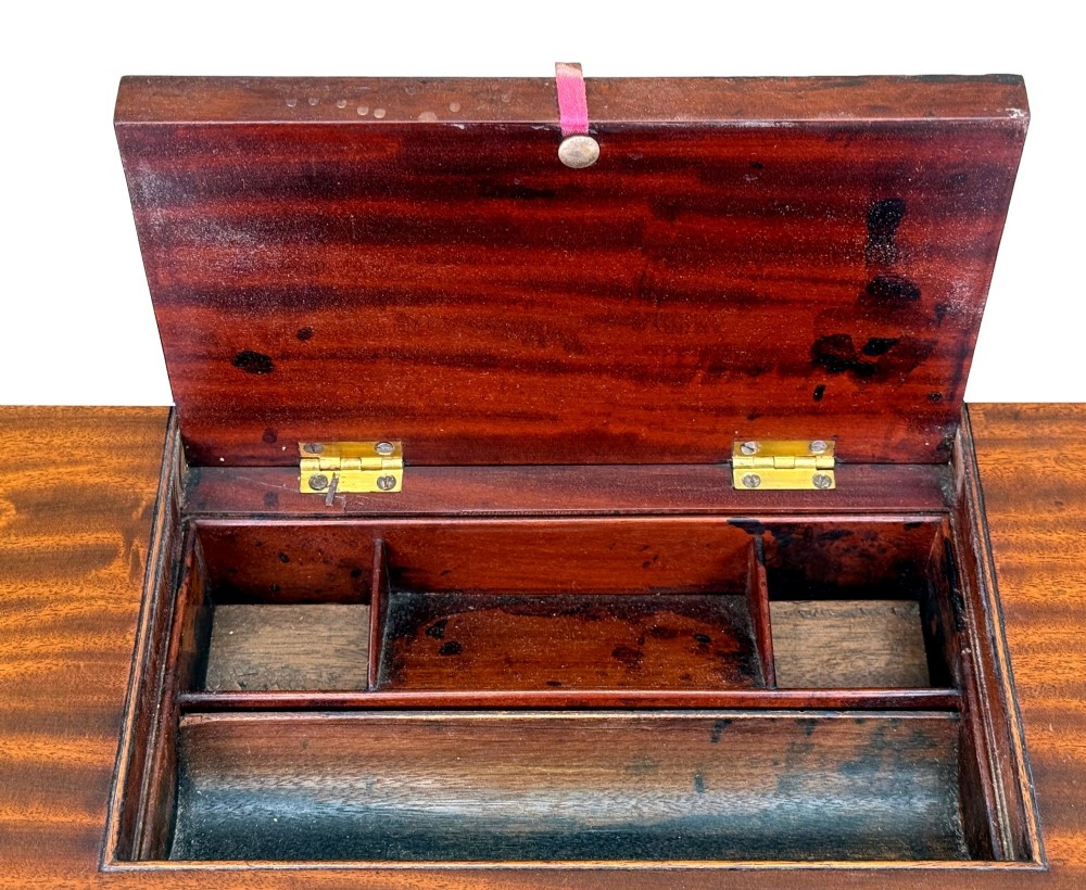 A Regency mahogany chamber writing table featuring a single frieze drawer, fluted turned legs on brass castors, and an inset surface hatch. View V