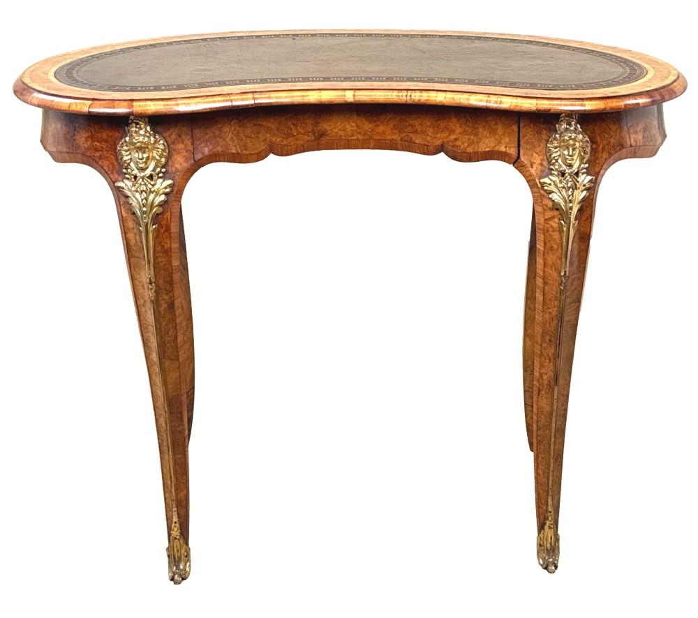 A 19th-century burr walnut kidney-shaped writing table featuring an inset leather top, gilt bronze espagnolette mounts, and cabriole legs. View XV