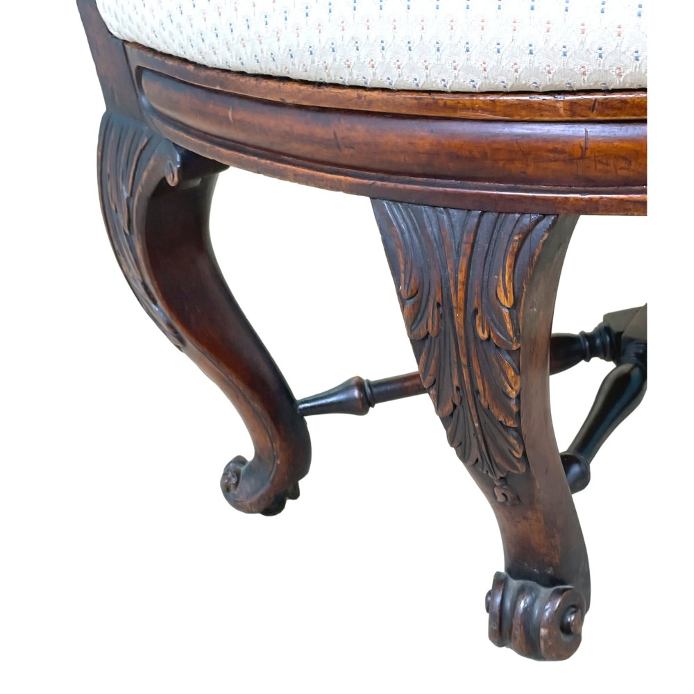 A 19th-century mahogany Burgermeister desk chair featuring a curved backrest with woven cane panels, carved armrests, an upholstered cream seat, and cabriole legs. View IX