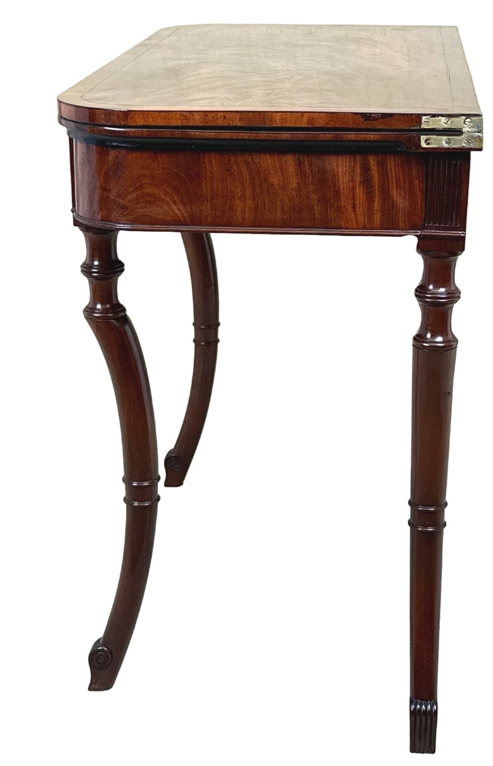 A Regency mahogany fold-over tea table featuring a flame mahogany frieze, reeded corner blocks, and four curved legs with ring-turned detailing. View X