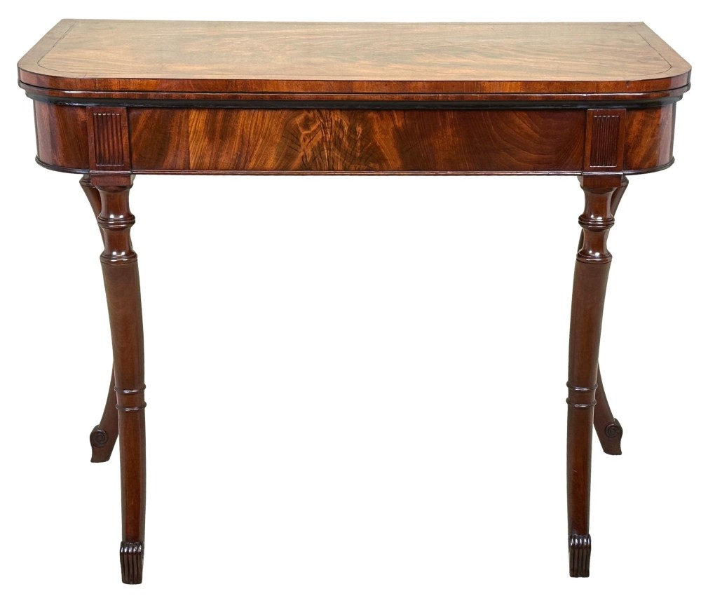 A Regency mahogany fold-over tea table featuring a flame mahogany frieze, reeded corner blocks, and four curved legs with ring-turned detailing. View XIII