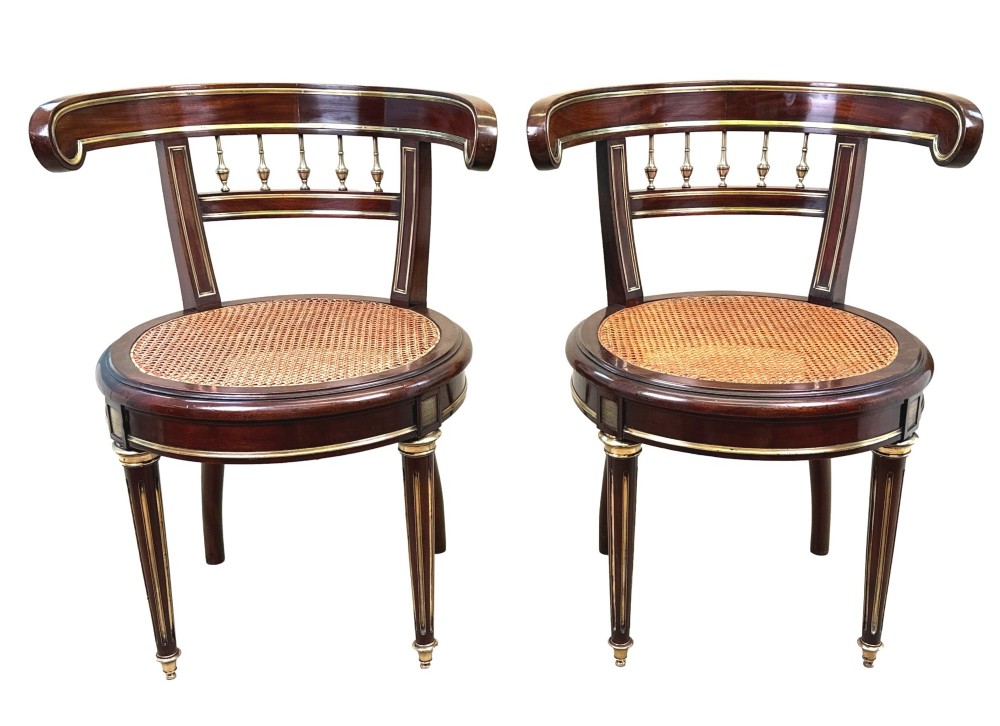 A pair of 19th-century French mahogany curved-back salon chairs with brass mounts, spindle details, woven cane seats, and turned front legs. View VIII