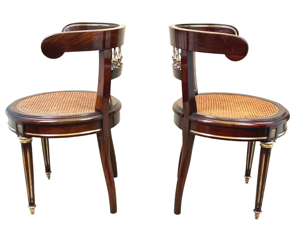 A pair of 19th-century French mahogany curved-back salon chairs with brass mounts, spindle details, woven cane seats, and turned front legs. View XI