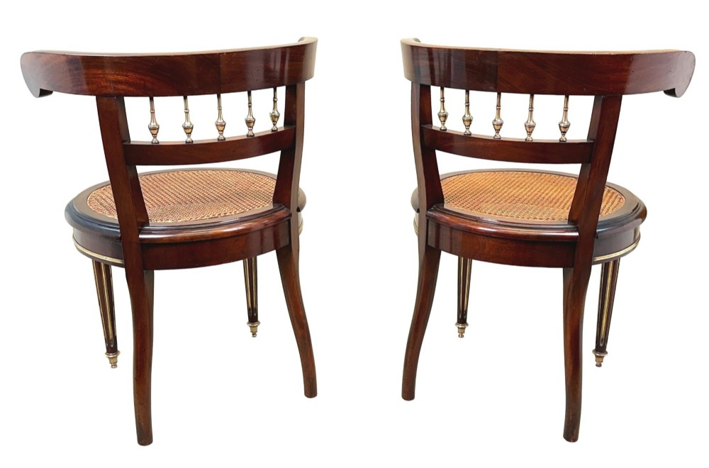 A pair of 19th-century French mahogany curved-back salon chairs with brass mounts, spindle details, woven cane seats, and turned front legs. View XII