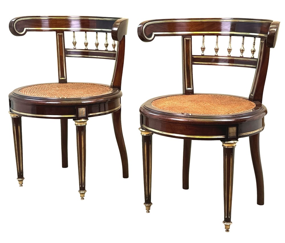 A pair of 19th-century French mahogany curved-back salon chairs with brass mounts, spindle details, woven cane seats, and turned front legs. View XIII