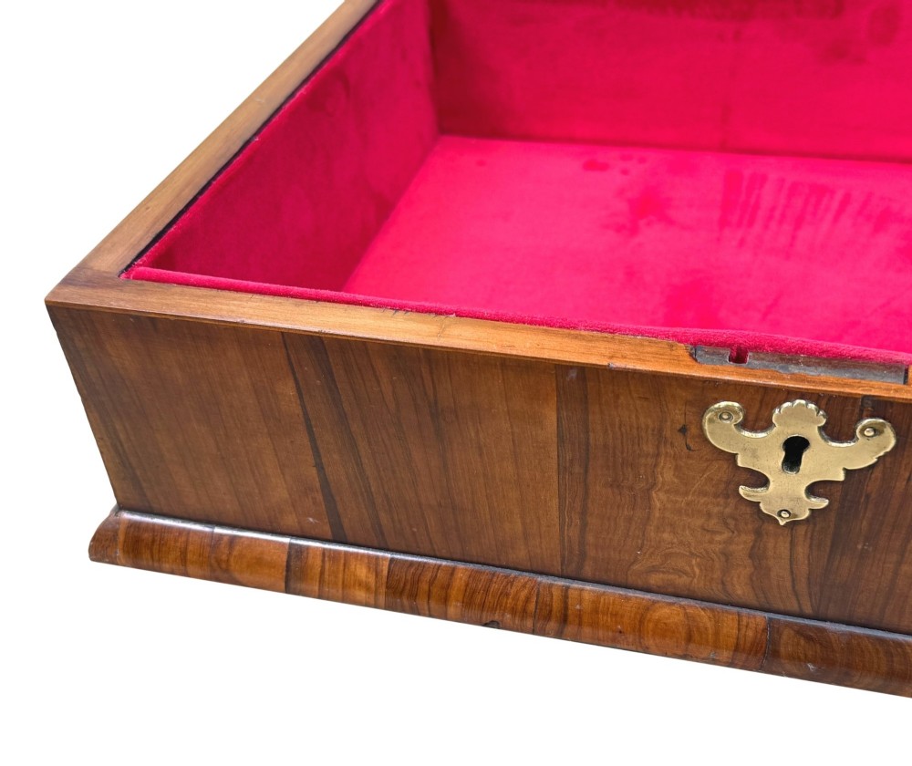 A shallow rectangular William and Mary period wooden box with laburnum oyster veneered patterns, concentric circular stringing on the lid, and a brass keyhole escutcheon on the front panel. View VIII