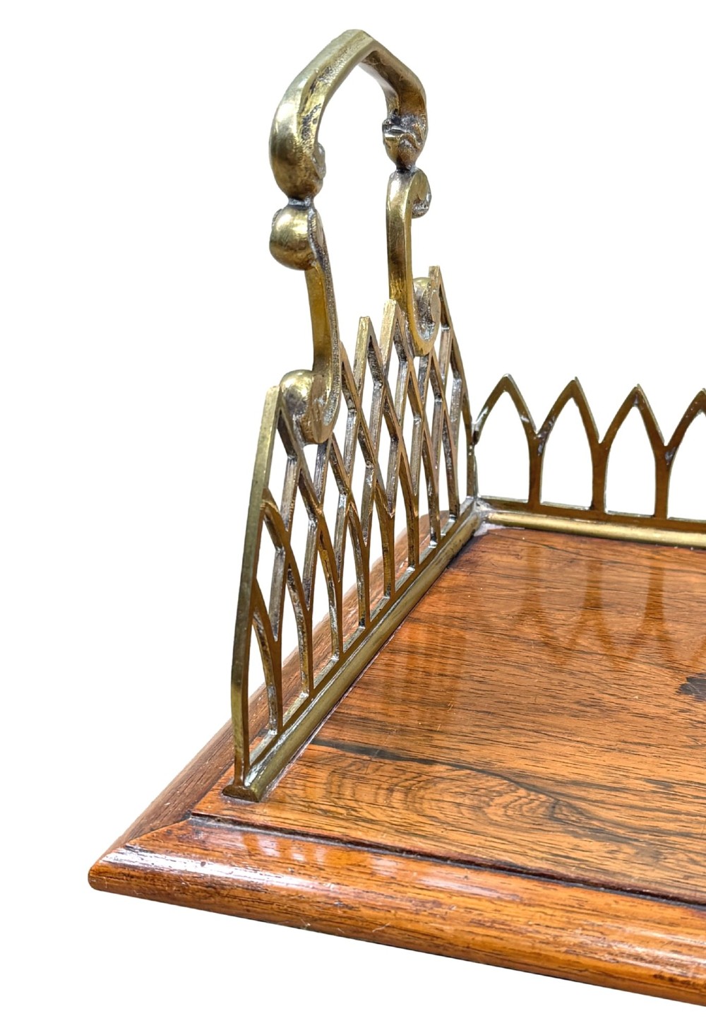 A rectangular rosewood desk tray with a polished grain surface, featuring decorative pointed brass gallery borders and arched carrying handles at each end. View VIII