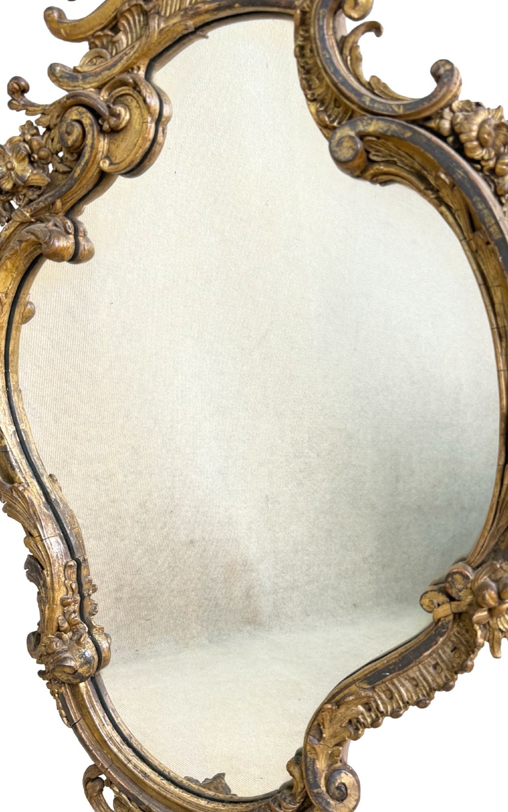 A pair of mid-19th-century cartouche-form wall mirrors featuring ornate carved giltwood and gesso frames decorated with scrolling foliage and floral cresting. View IX