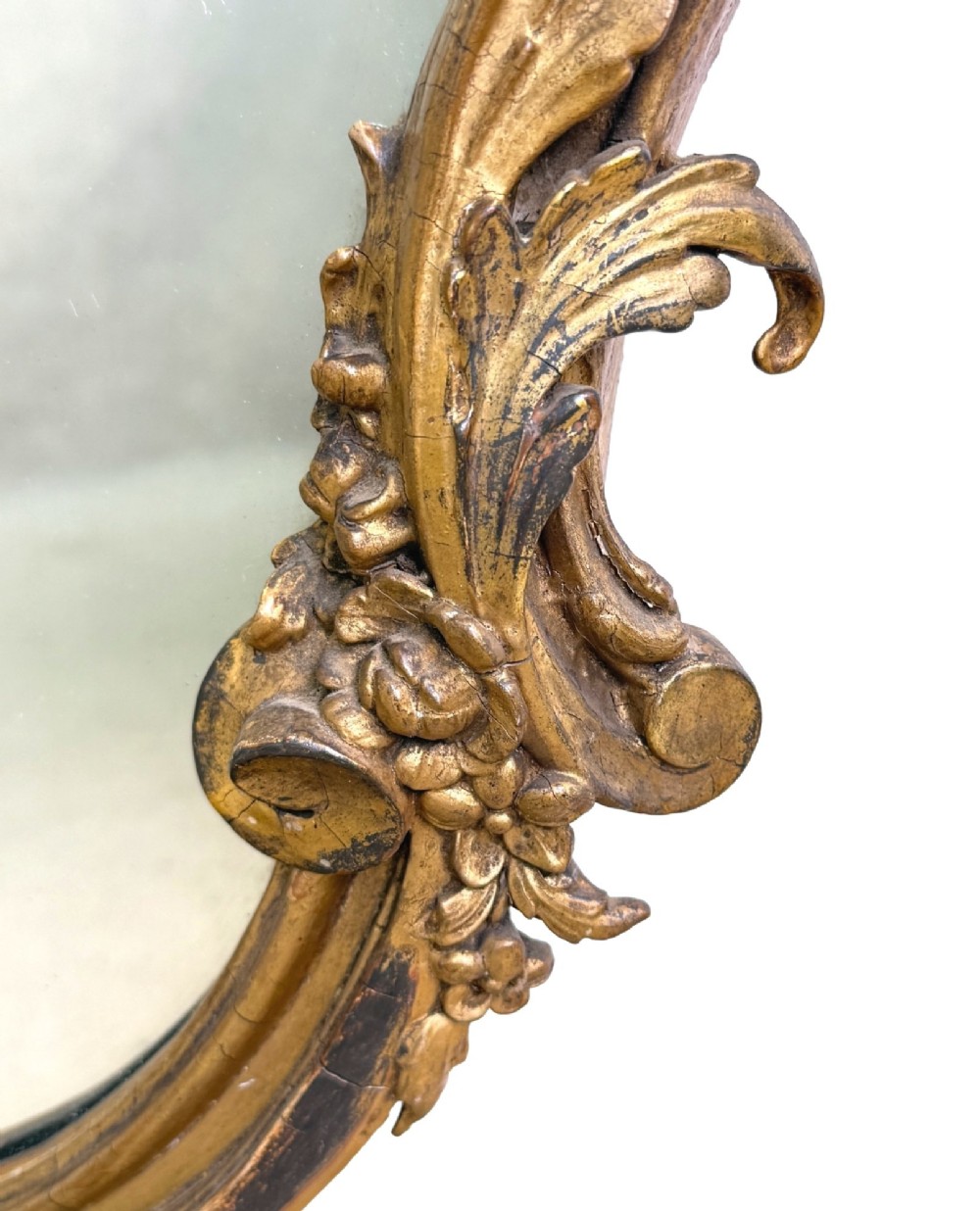 A pair of mid-19th-century cartouche-form wall mirrors featuring ornate carved giltwood and gesso frames decorated with scrolling foliage and floral cresting. View XII