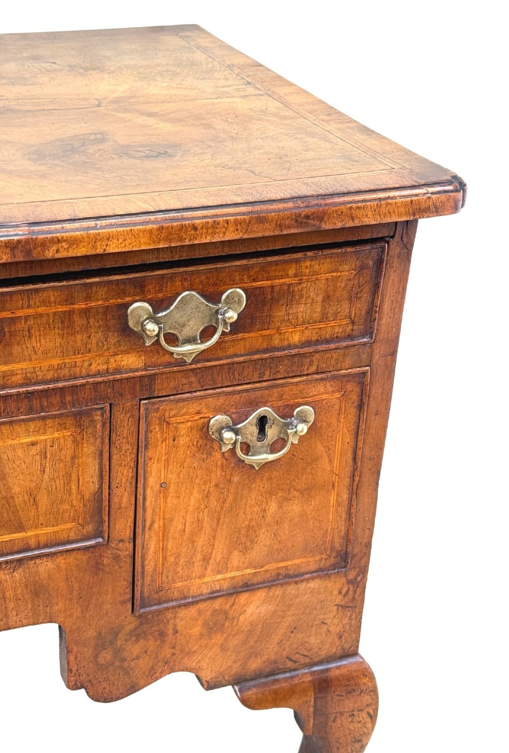 An early 18th-century George I walnut lowboy with four drawers, brass drop handles, a shaped apron, and cabriole legs with pad feet. View V