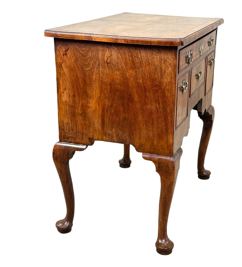 An early 18th-century George I walnut lowboy with four drawers, brass drop handles, a shaped apron, and cabriole legs with pad feet. View VI