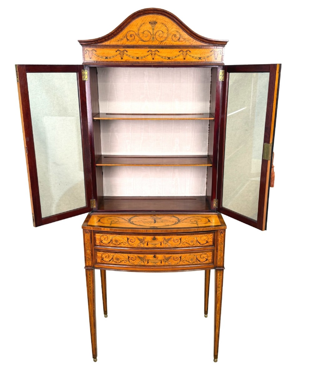 A 19th-century inlaid satinwood display cabinet featuring an arched cresting, glazed upper doors, marquetry frieze drawers, and square tapered legs. View III