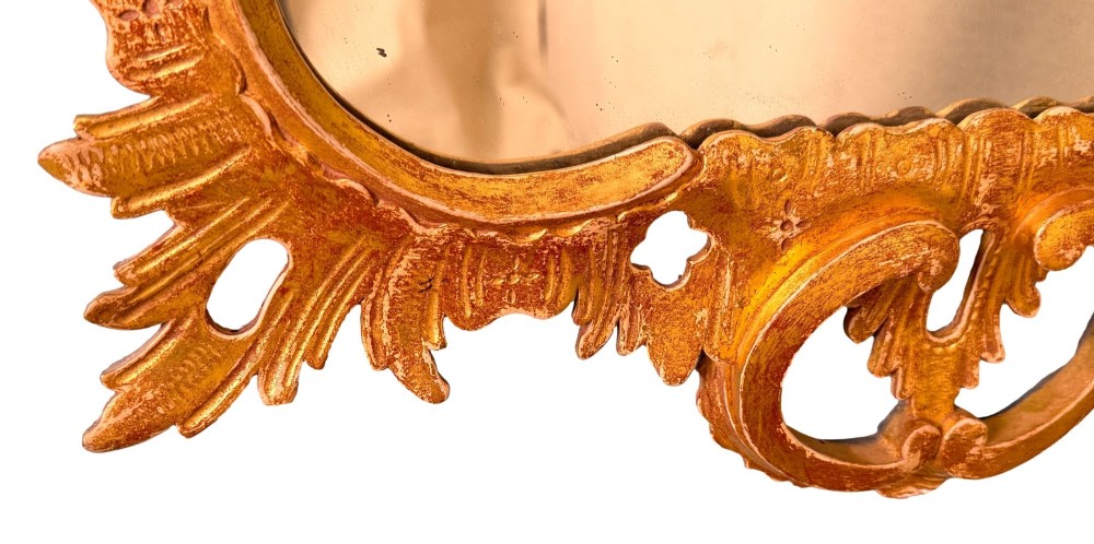 A pair of 18th-century Chippendale style giltwood wall mirrors featuring carved Rococo scroll frames topped with bird crests. View X