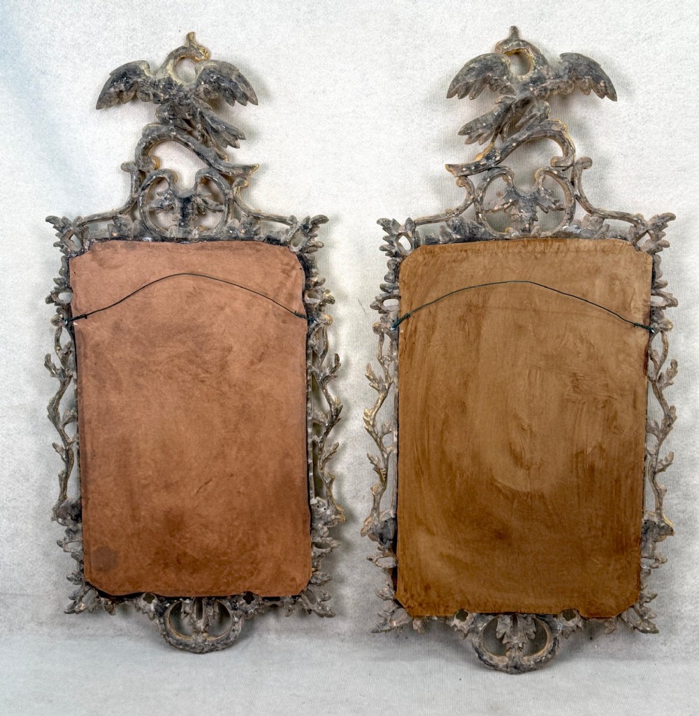 A pair of 18th-century Chippendale style giltwood wall mirrors featuring carved Rococo scroll frames topped with bird crests. View XIII