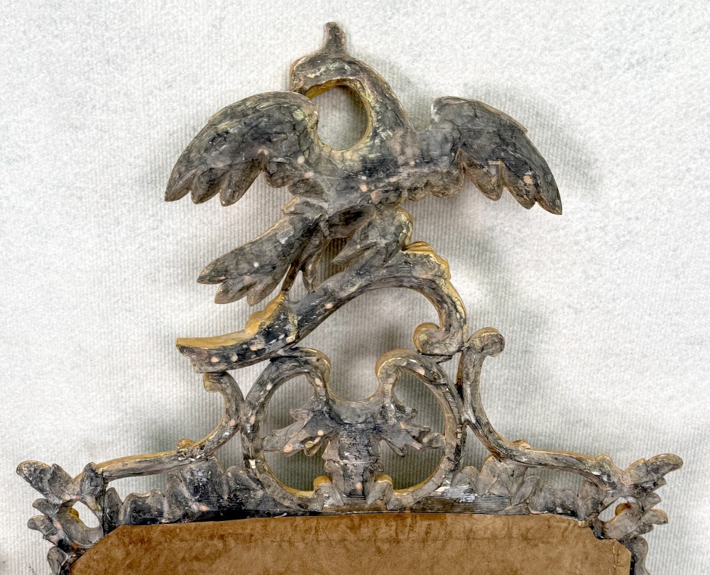 A pair of 18th-century Chippendale style giltwood wall mirrors featuring carved Rococo scroll frames topped with bird crests. View XV