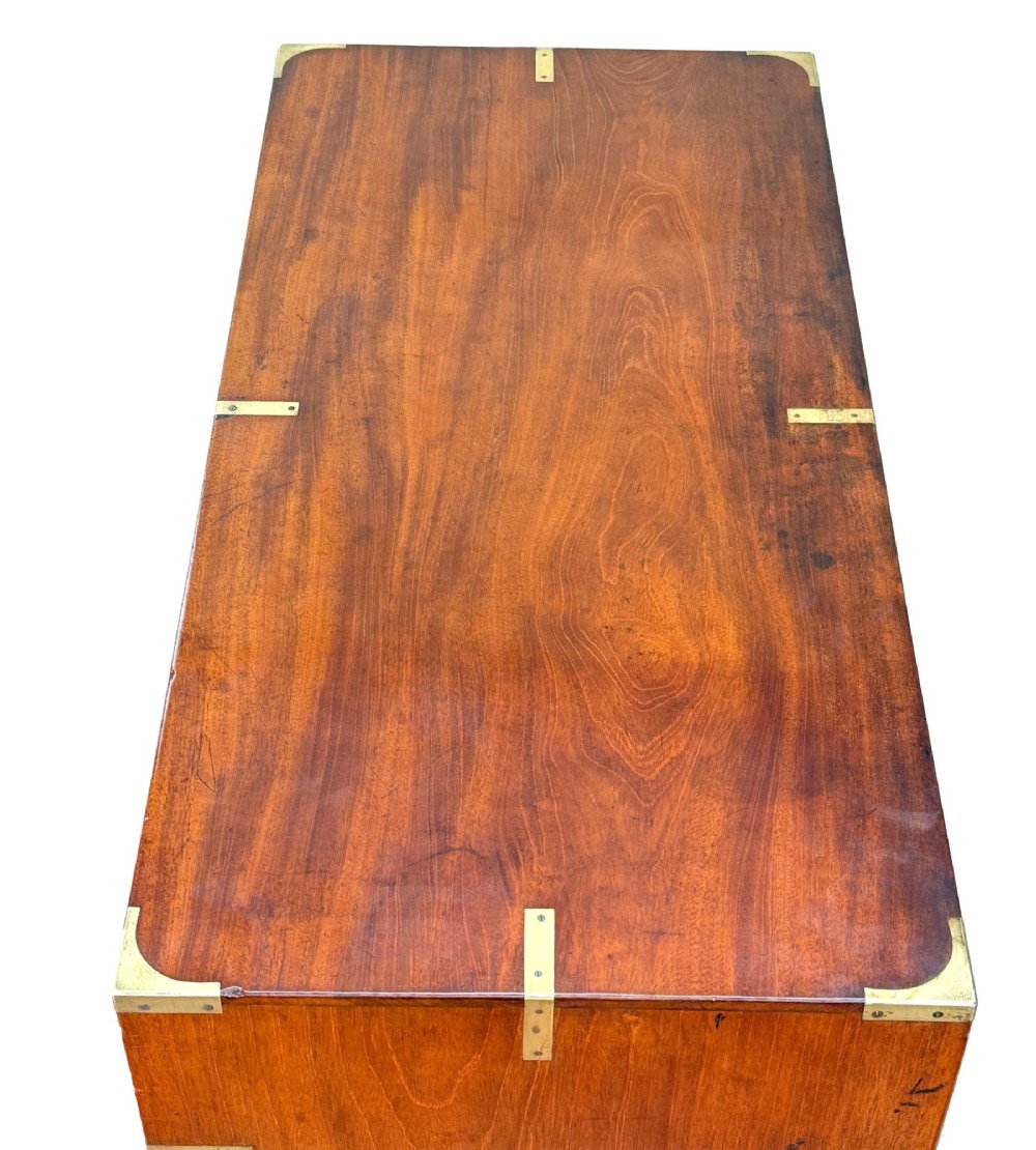 A mid-19th century camphor wood military campaign chest of drawers featuring brass corner brackets, flush handles, and two separate stacking sections on turned feet. View II
