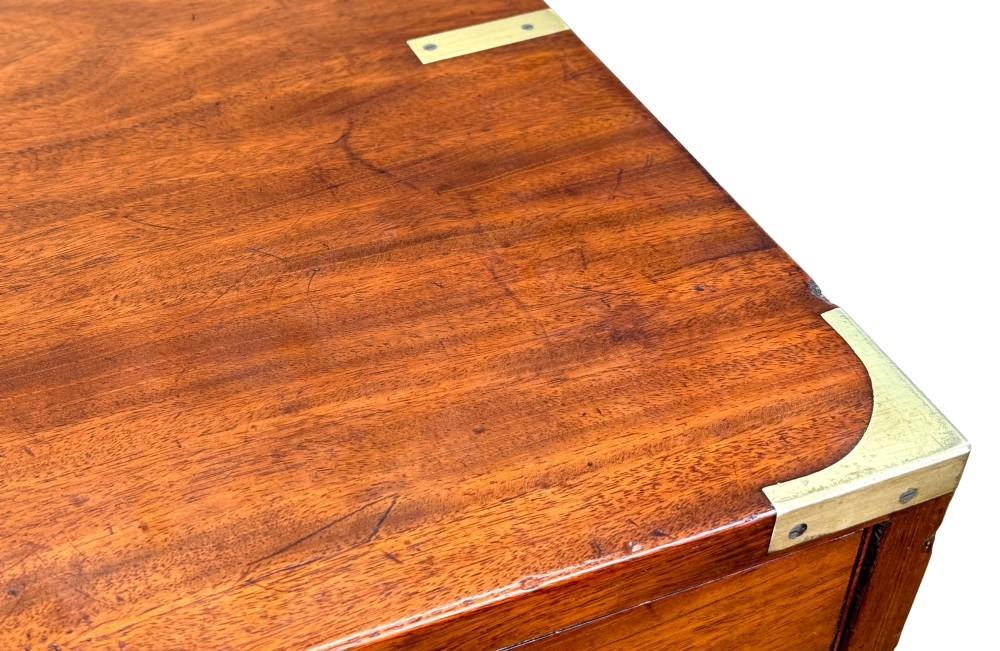 A mid-19th century camphor wood military campaign chest of drawers featuring brass corner brackets, flush handles, and two separate stacking sections on turned feet. View X