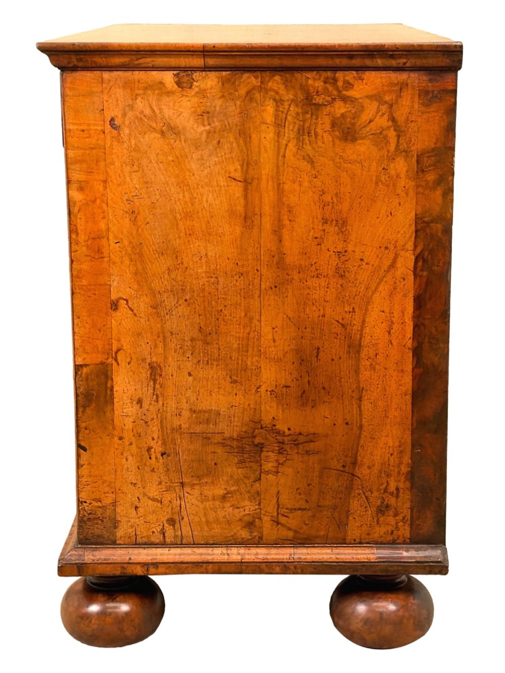 An early eighteenth-century Queen Anne walnut chest of drawers featuring two short over three long graduated drawers, brass handles, pierced escutcheons, and turned bun feet. View VIII