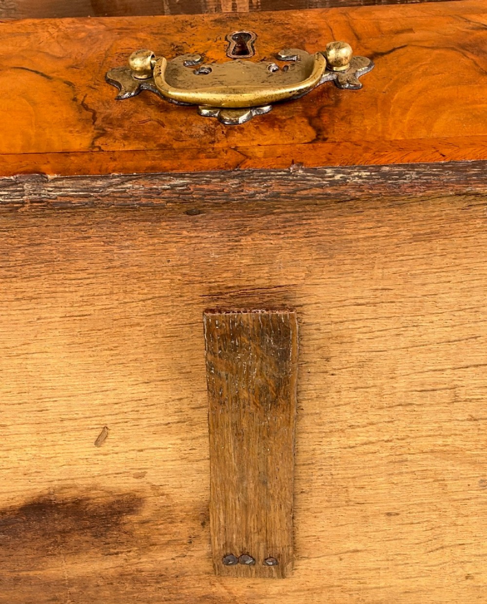 An early eighteenth-century Queen Anne walnut chest of drawers featuring two short over three long graduated drawers, brass handles, pierced escutcheons, and turned bun feet. View IX