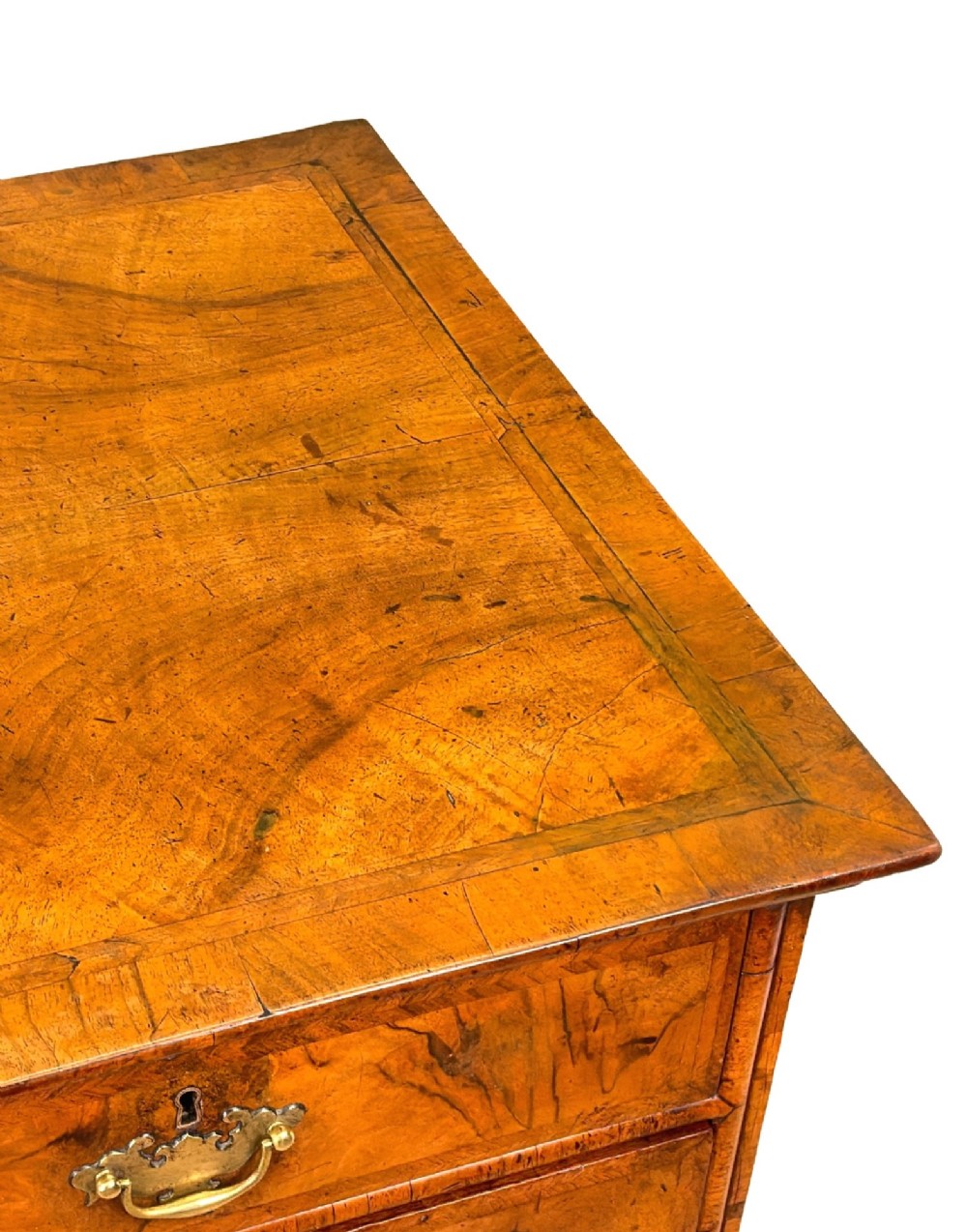 An early eighteenth-century Queen Anne walnut chest of drawers featuring two short over three long graduated drawers, brass handles, pierced escutcheons, and turned bun feet. View XIII