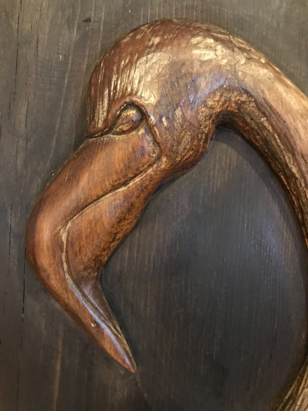An Arts and Crafts relief carved wooden wall panel depicting two flamingos within a dark painted field and framed border. View III
