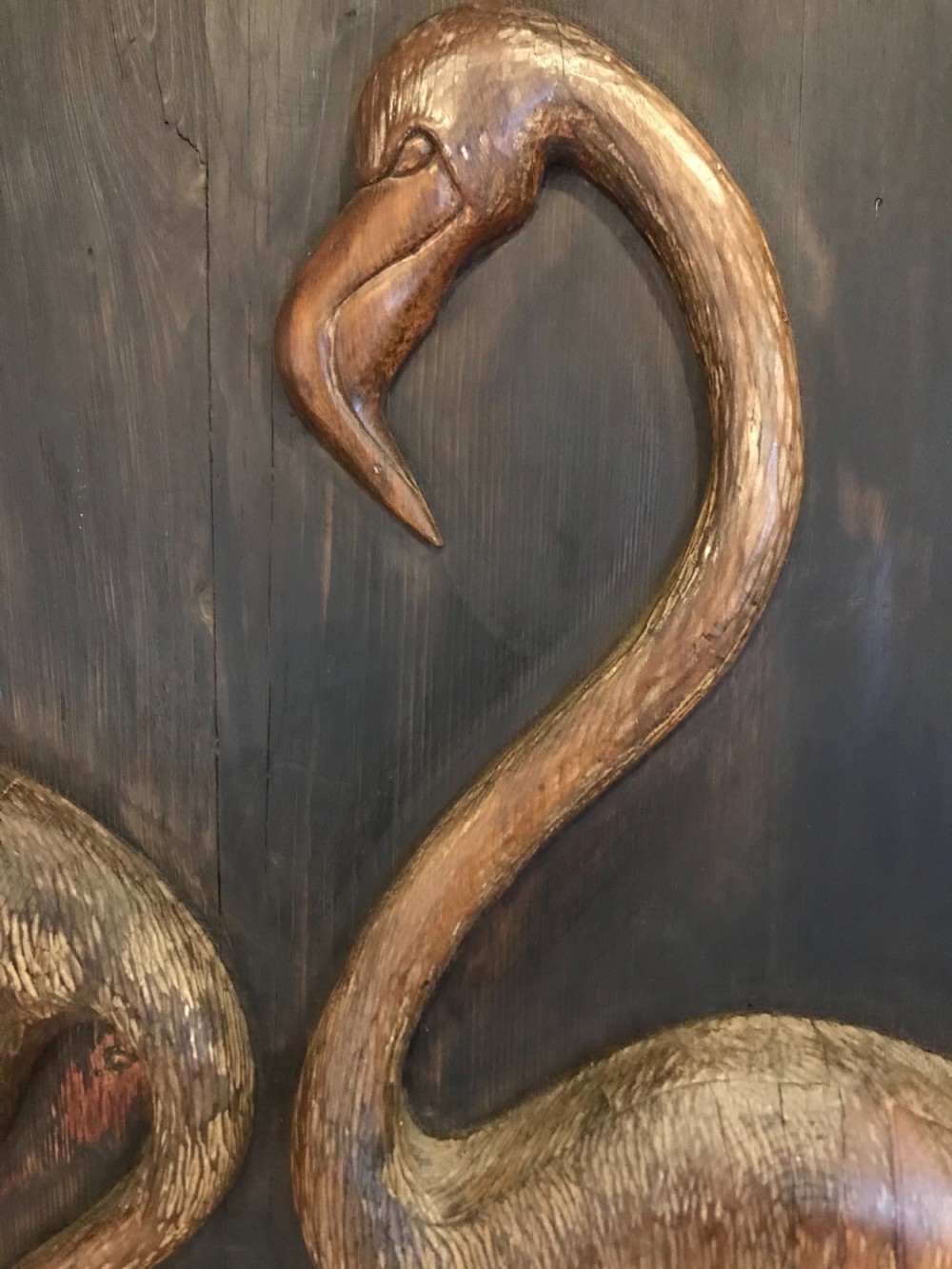 An Arts and Crafts relief carved wooden wall panel depicting two flamingos within a dark painted field and framed border. View IV