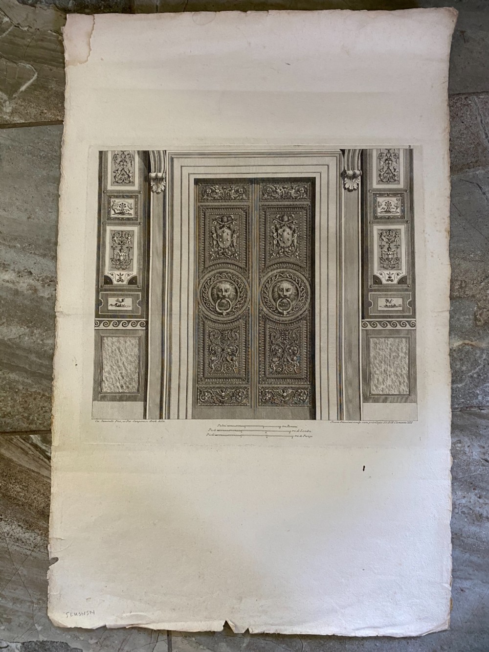 An eighteenth-century monochrome architectural engraving depicting detailed carved Vatican doors framed by decorative grotesque panels and classical mouldings. View II