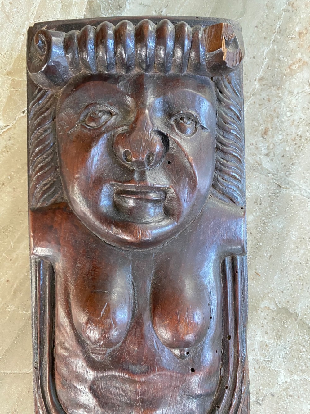 A dark brown 17th-century carved oak caryatid panel depicting a stylised female figure with carved scrollwork details. View II