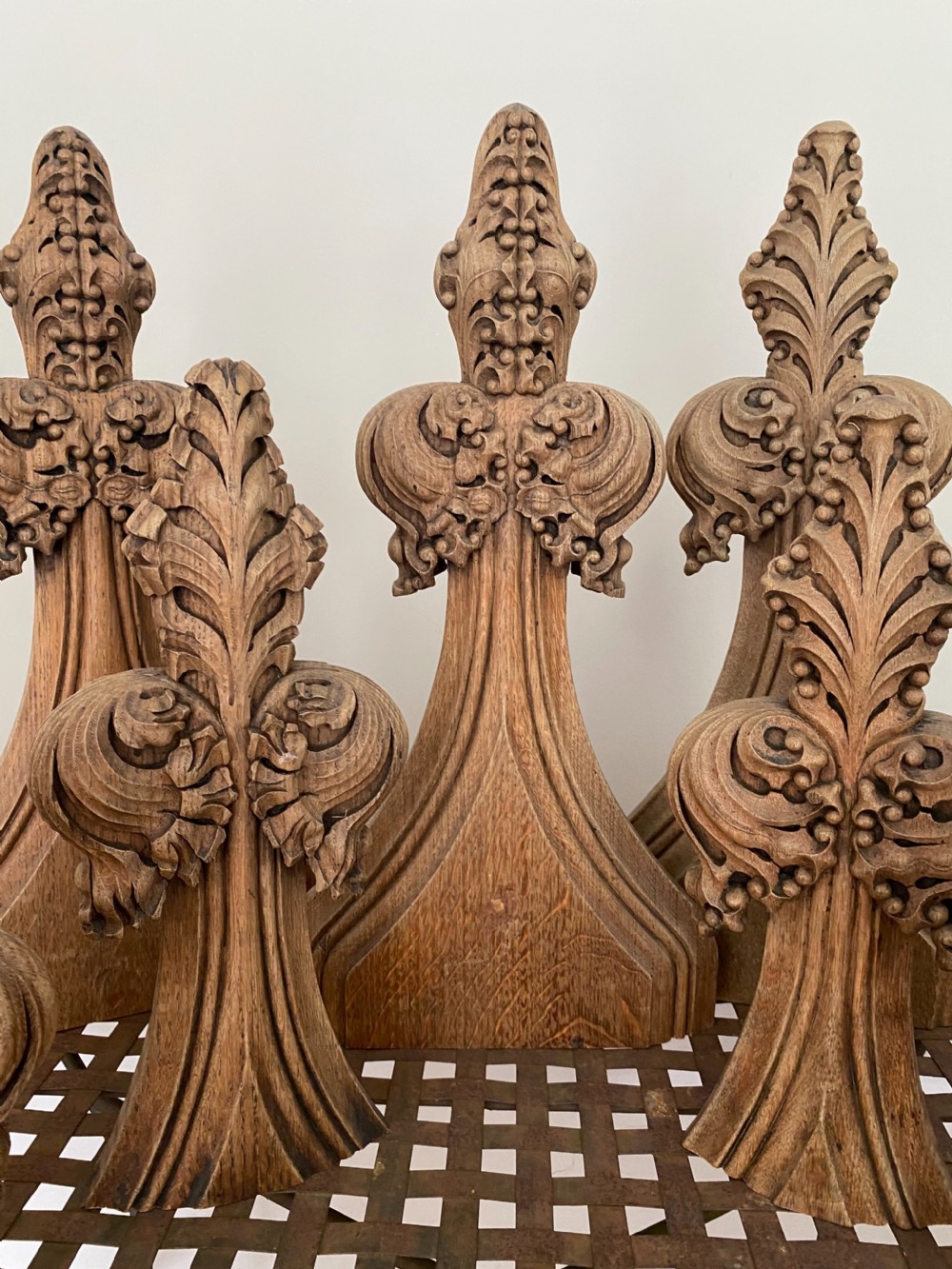 A set of eight hand-carved oak Gothic finials featuring crocket and fleur-de-lis motifs in warm brown timber. View II
