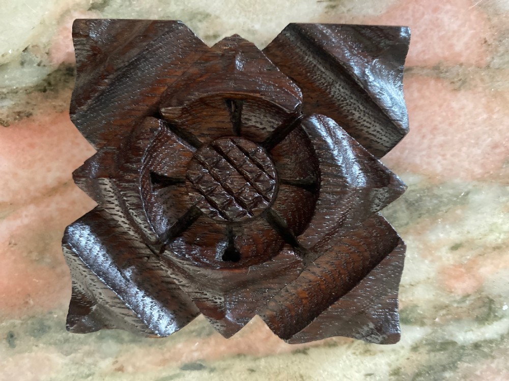A square hand-carved dark oak architectural boss featuring a raised central floral Tudor rose motif.