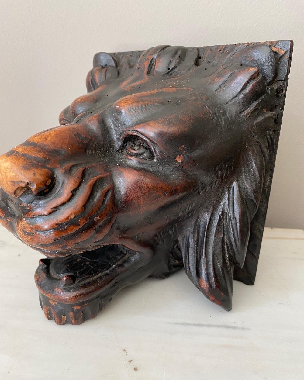 A 19th-century carved walnut lion head sculpture featuring a detailed mane and open mouth.